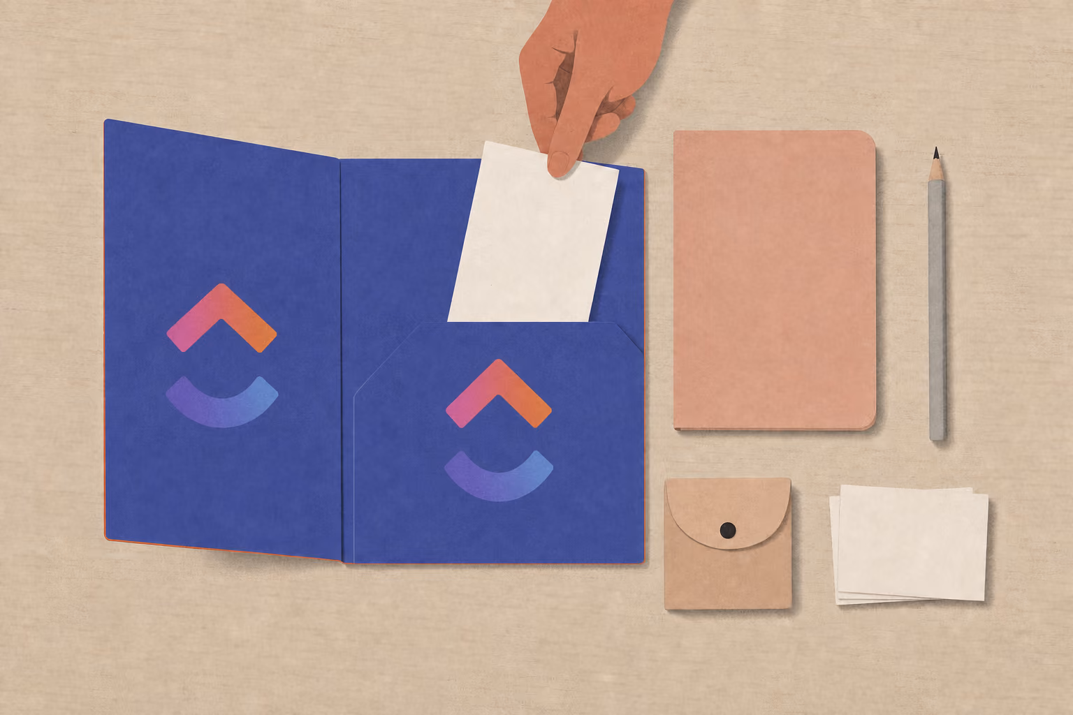 A hand drops a blank card into an open in-box folder beside a notebook, pencil, and wallet