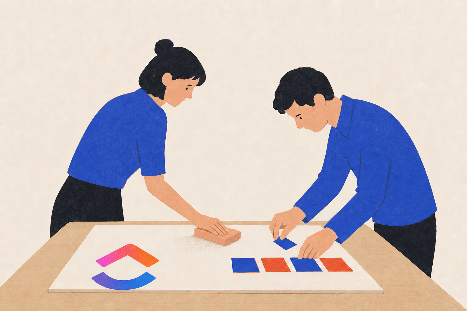 Two people work over a dry-erase board as one wipes it and the other arranges note cards